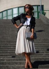 A light fluffy skirt below the knee in combination with a leather jacket