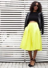 A bright skirt below the knee in combination with a dark top