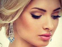 Make-up mit Brauntönen unter einem Pfirsichkleid.