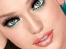 Make-up mit Grüntönen unter einem Pfirsichkleid.