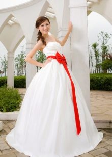 A magnificent wedding dress with a scarlet bow