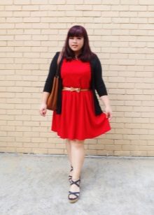 Red knitted dress for a full girl with a golden belt, a black cardigan and sandals