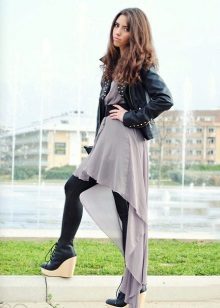 Robe asymétrique en combinaison avec une veste en cuir et des collants serrés