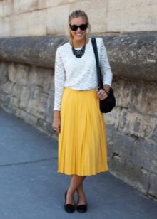 A yellow skirt below the knee in combination with a white blouse