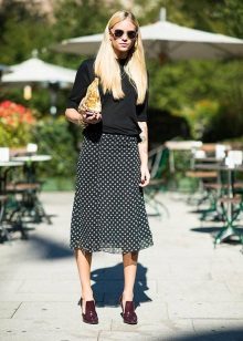 A small print skirt below the knee in combination with a plain sweatshirt