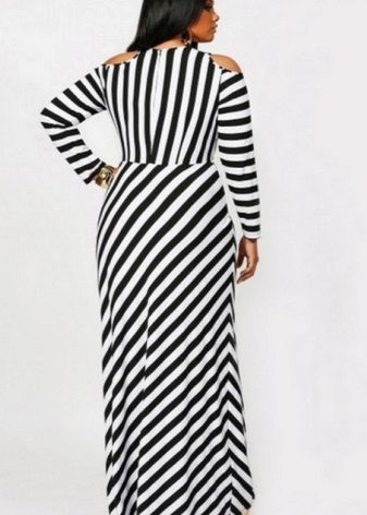 A long striped floor-length black and white dress of a simple cut for a plump woman (girl)
